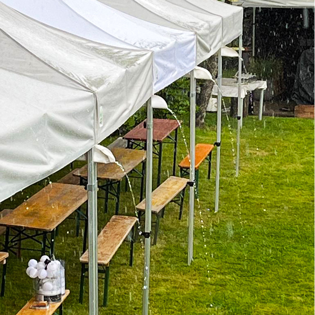mehrere Faltzelte mit montierter Regenrinnen auf Rasenfläche verbunden