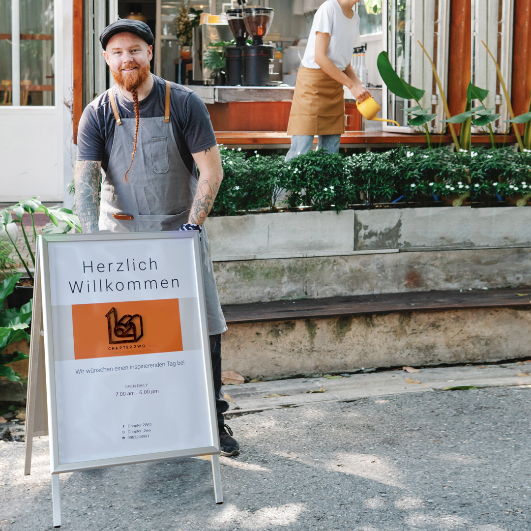 Kundenstopper mit farbig bedruckter Bespannung im Außenbereich, vor einem Mann