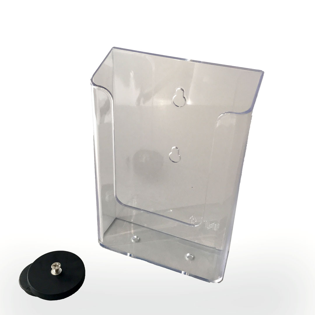 Ein transparenter Prospekthalter und ein separater, runder Magnet zur Wandbefestigung liegen auf einer weißen Oberfläche.